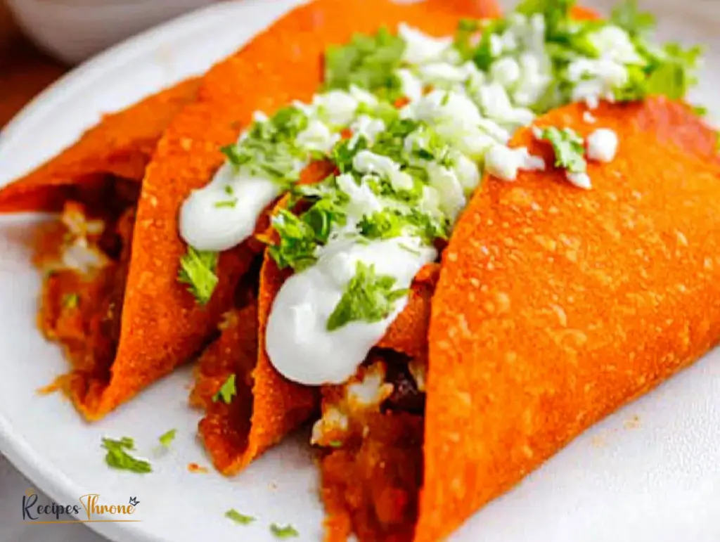 Three Enchiladas Potosinas topped with Mexican cream and fresh cilantro, served on a white plate