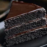 Moist black velvet cake sliced with cream cheese frosting